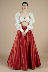 Twisted knot draped blouse with puff sleeves and red silk brocade skirt